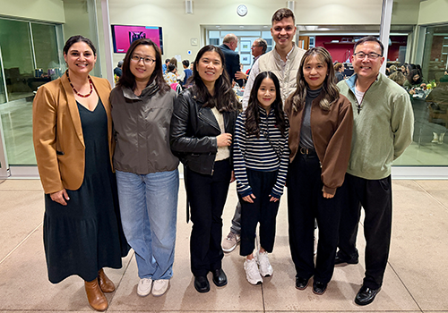 A group of seven people standing together and smiling